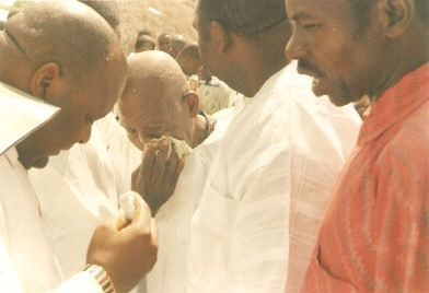 Baba weeps at Mama's burial.