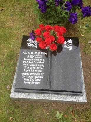 Arthur memorial stone at the cemetary, with red roses/purple petunias.