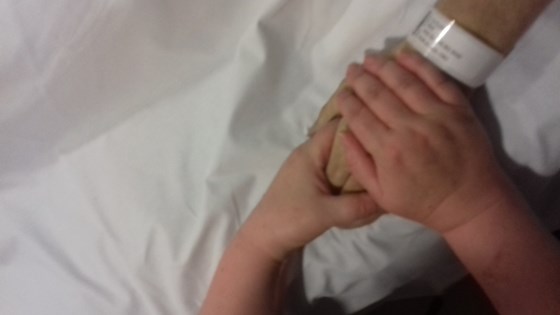 Donna holding Mark's hand in the hospice