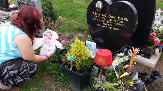 Rebecca and Martin showing baby Olivia grandad's grave