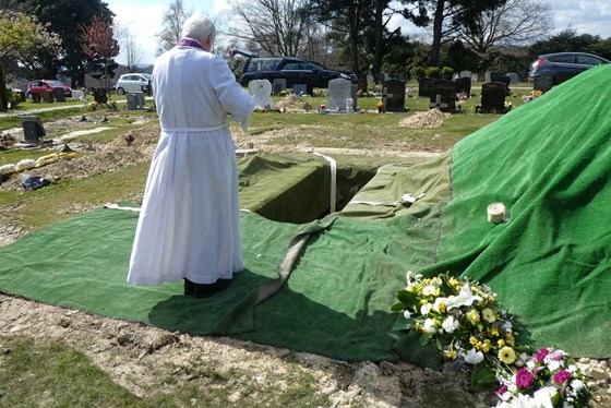 The clergyman leads the mourners in prayers as Leonie is laid to rest