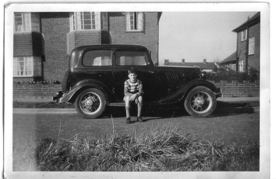 Bob on running-board of his father's car in front of their house. 1961?