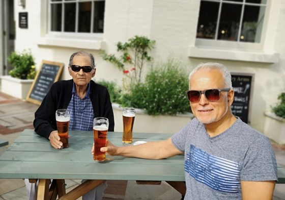 Enjoying a beer.  But, which one is the father, and which the son?