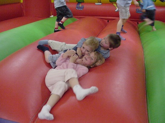 Cuddles on a bouncy castle with cousins Ellena and Matthew in 2004