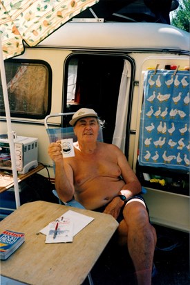 Dad sitting outside caravan with cup of tea