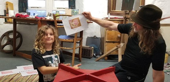 In the bothy at Everybist, teaching Magnus to make lino-cut prints