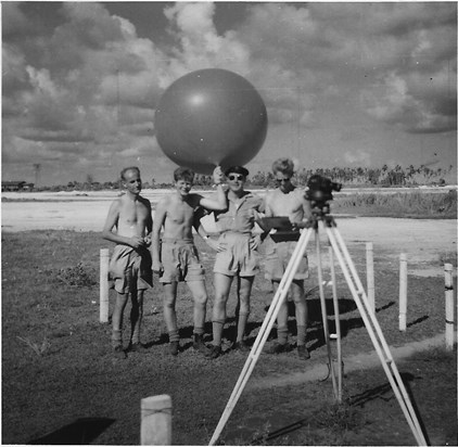 Releasing a pilot balloon to measure upper winds with a little help from the Signals guys, Gan 1959. 