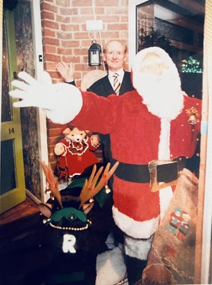 Dad with his legendary homemade Christmas display, complete with animatronic Santa and Rudolph.