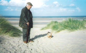 A Norfolk lad with a Norfolk terrier on a Norfolk beach