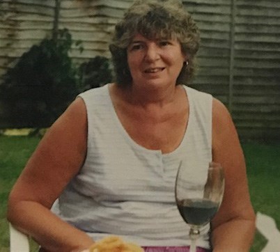 Joyce in the garden enjoying a glass of wine.