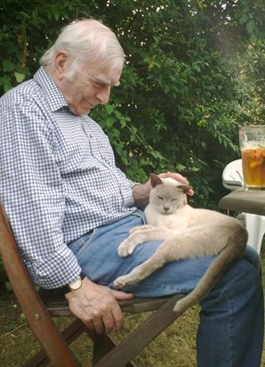 Daddy with Ossie in the garden in summer with a Pimms.