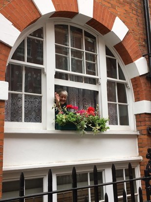 Waving from her beloved flat