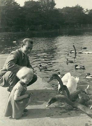 Becky and her dad feeding the swans and cygnets in East Park in Hull in 1953