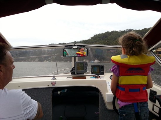 Elise teaching Grandad how to drive a boat