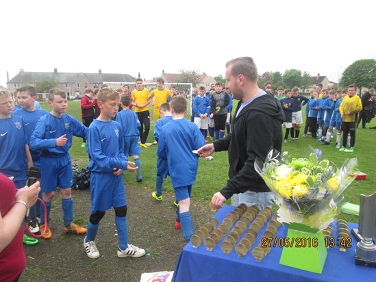 Beezy's grandson Gary Docherty presenting the medals