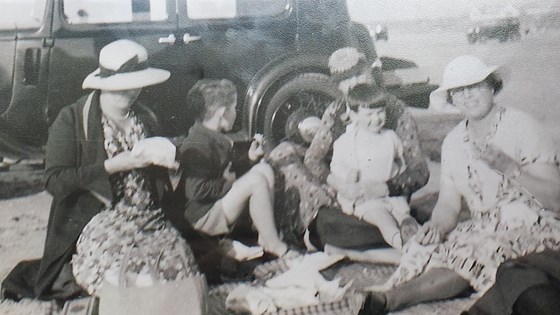 Dad on the beach with the car! He is on the family's maid Florrie's lap, with his mum, brother John and i