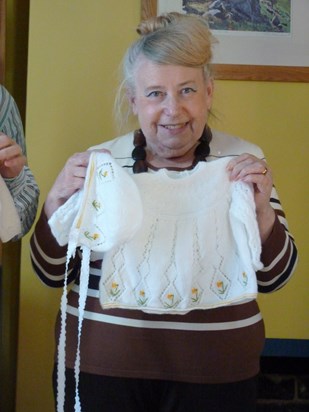 Josie with one of the outfits that she made for Rebecca. It has daffodils embroidered on it.