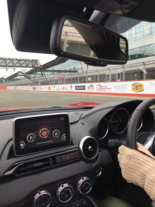 Dad driving his MX5 down the pit straight at Silverstone Circuit (Grandpa's driving gloves!)