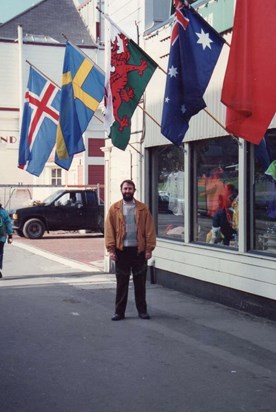 Of course he's standing under the Welsh flag.