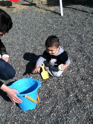 nick playing in the gravel with grandma 