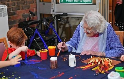 Industrious painting at day centre with children from a local school