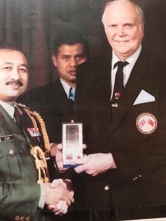 Gordon receiving his medal from  Malaysia