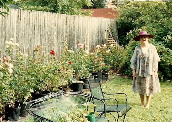 Peg with her rose garden and fruit orchard in background