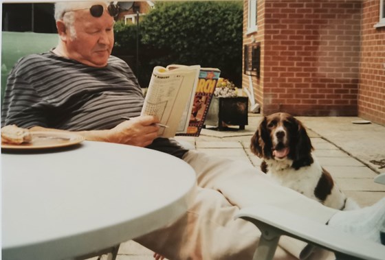 Geoff sunbathing with a puzzle mag and Sprocket - 2003
