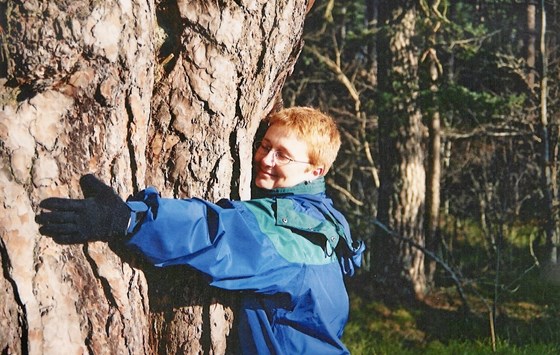 Hugging a tree somewhere probably in Scotland