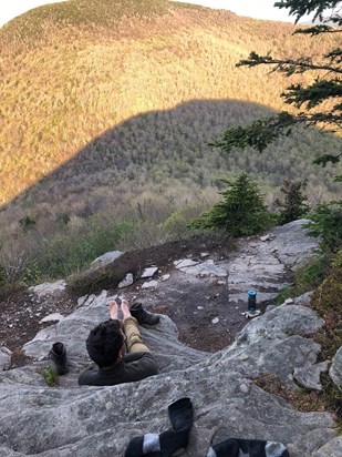 Marco taking off his boots and enjoying the sunset after a long hike, May 2018