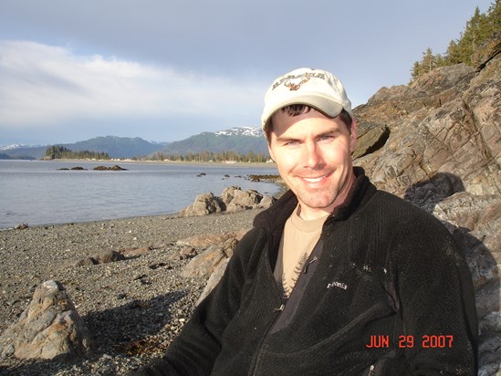 Kevin on the beach in Seldovia in front of our rustic cabin