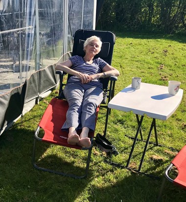 Mum enjoying the sun in June 2022 with a cup of tea. 