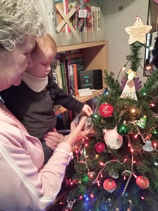 Joseph putting Auntie Jo's bauble on the Christmas tree. 2023