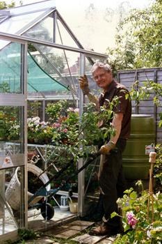 John and peach tree in greenhouse