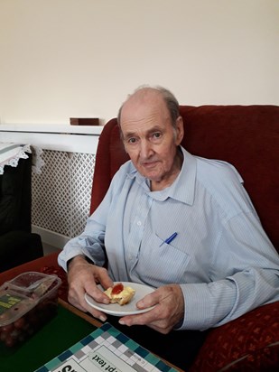 July 2019 enjoying a cream scone whilst doing a crossword