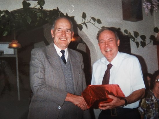 Ron Chorley presenting Harry with a camera to mark his 21 years of working at Chorleys November 1990