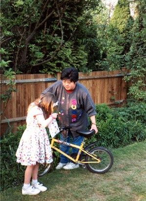 Amy very patiently helping me with my bike while I was preoccupied with sweets! (1993)